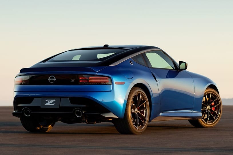 Granatowy Nissan Z stoi na pustym chodniku; widziany z tyłu, po lewej stronie.