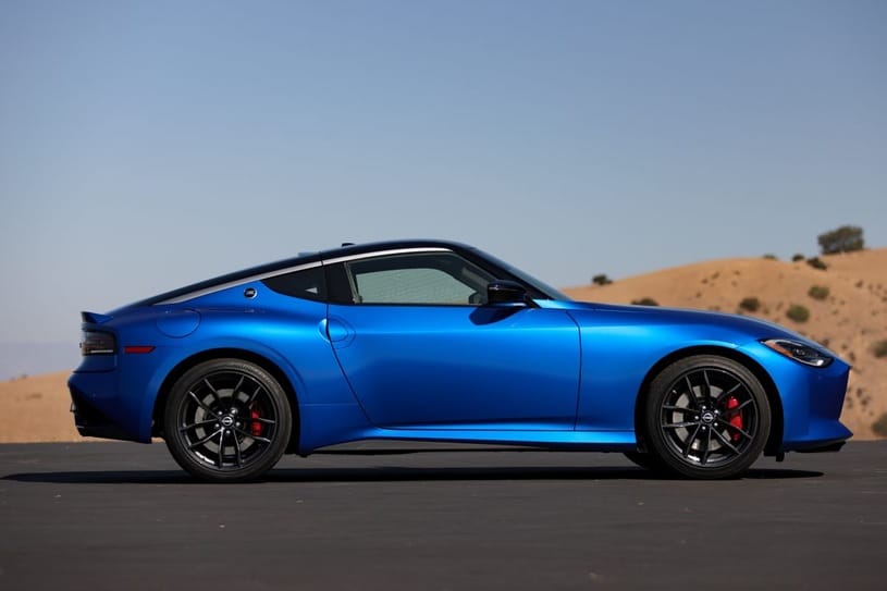 Niebieski Nissan Z stoi na asfalcie, a w tle widać wzgórza i czyste niebo.