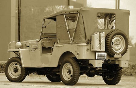 Wojskowy jeep w stylu Land Cruisera, brezentowy dach, koło zapasowe i kanister, plener.