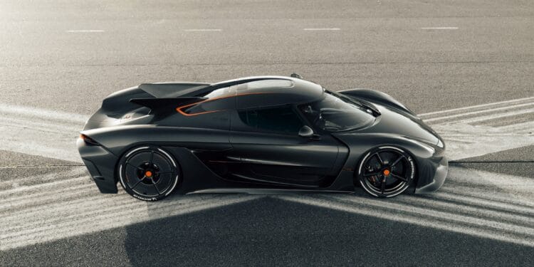 Czarny Koenigsegg Jesko Absolut stoi na asfalcie, a pod nim widoczne są ślady opon w kształcie litery X.