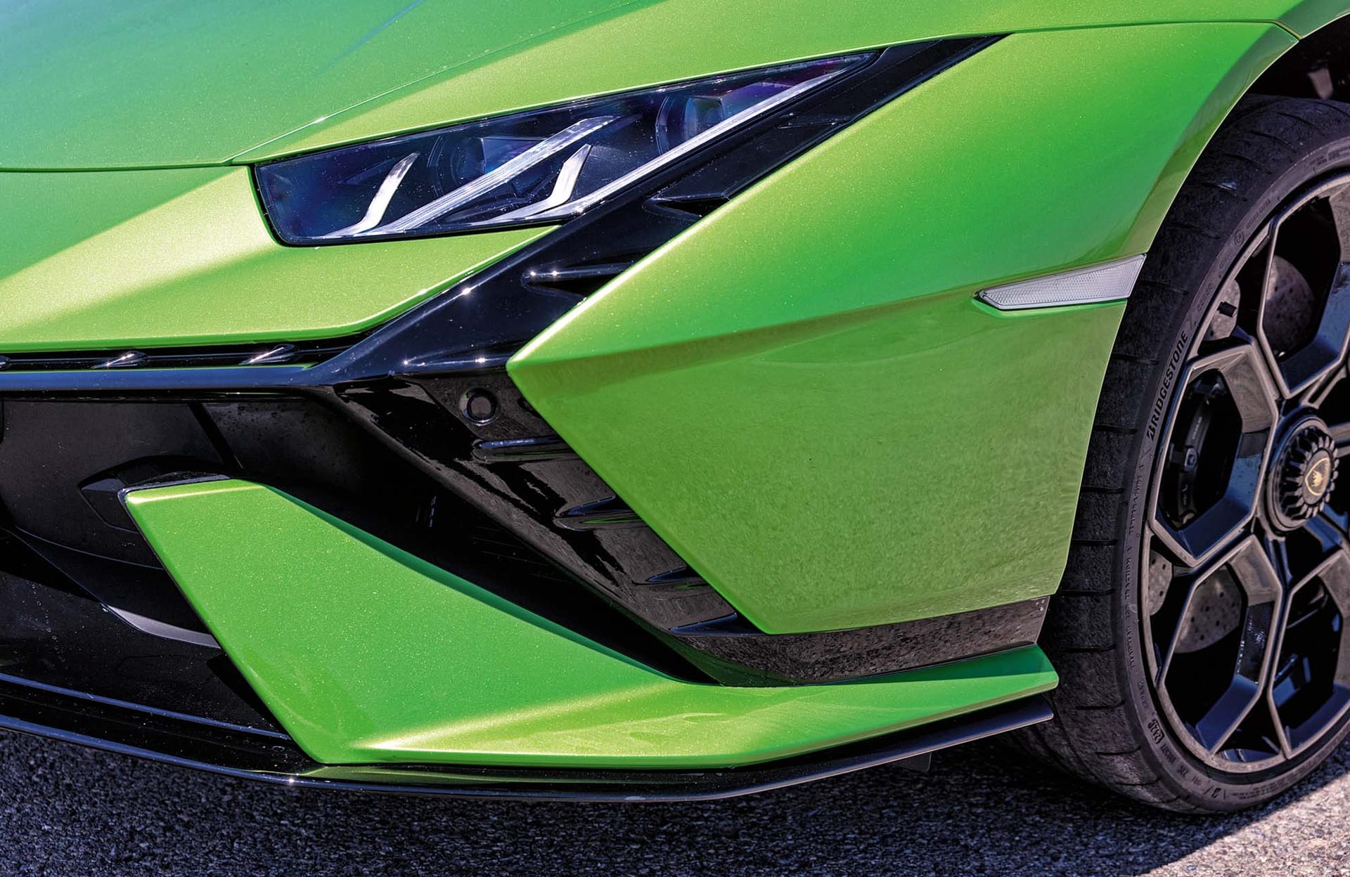 Przedni zderzak zielonego Lamborghini Huracan Tecnica z reflektorem, kołem i zderzakiem.