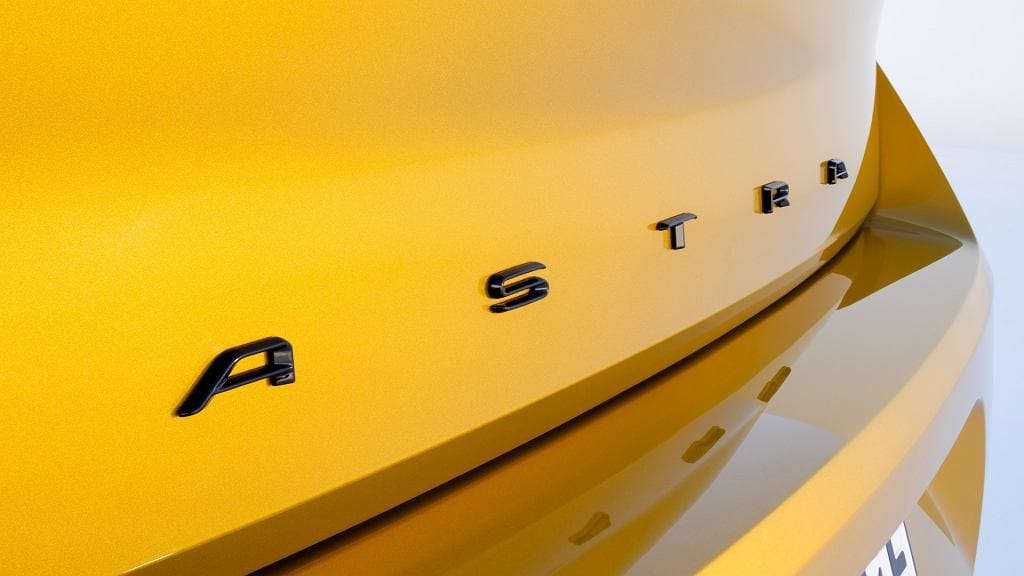 Tył żółtego Opla Astry z czarnym napisem „ASTRA” na klapie bagażnika.