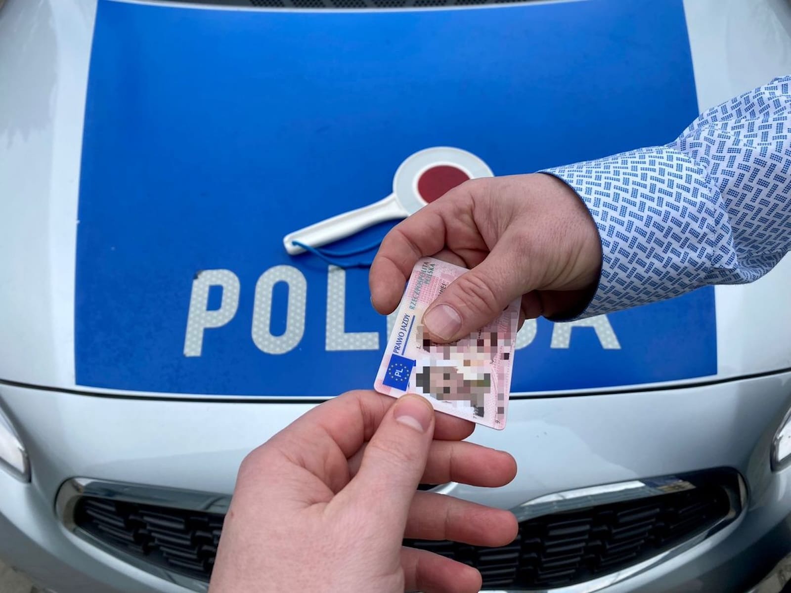 ręka policjant zabiera prawo jazdy