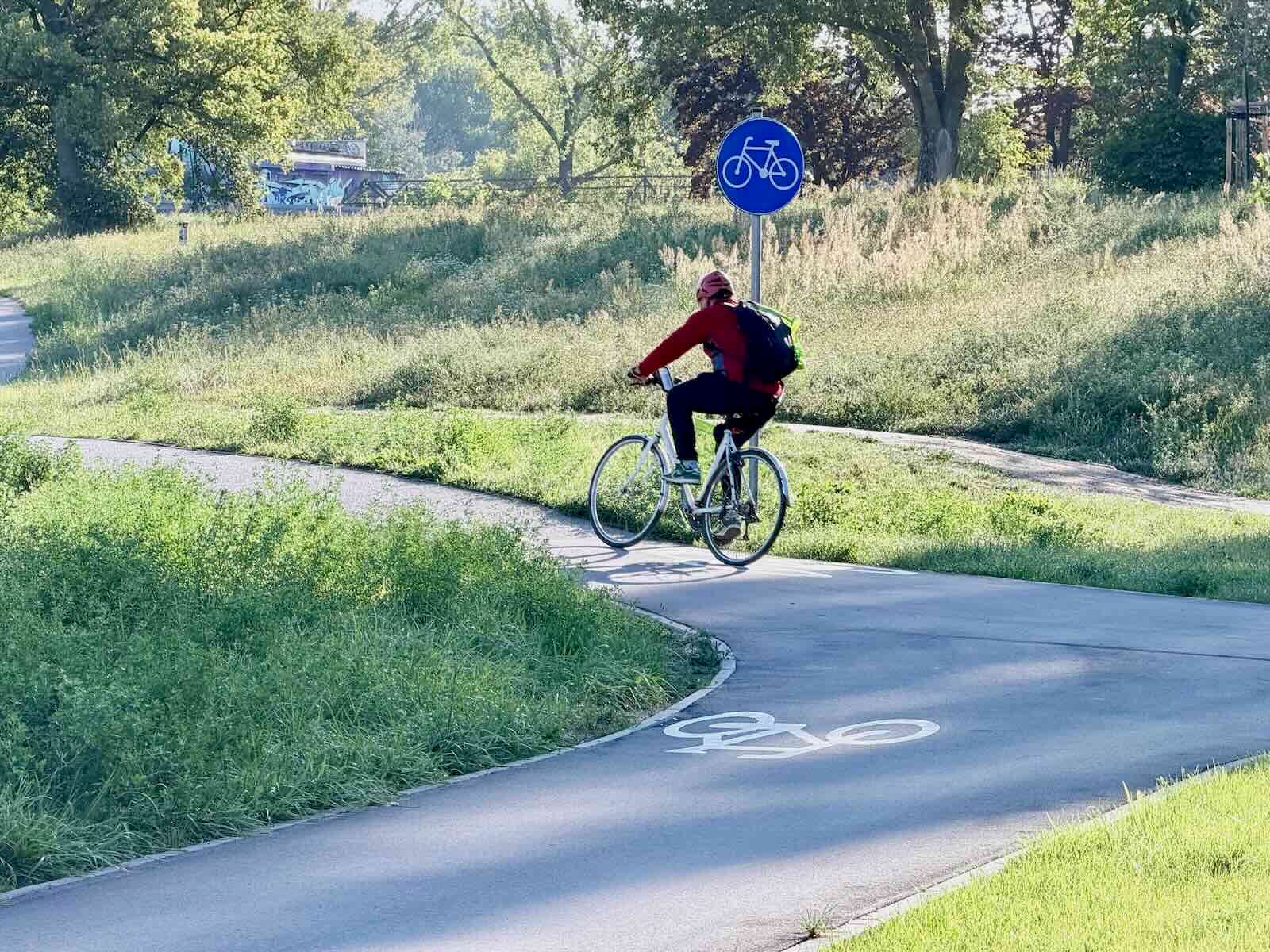droga dla rowerów po której porusza się rowerzysta znak poziomy i pionowy