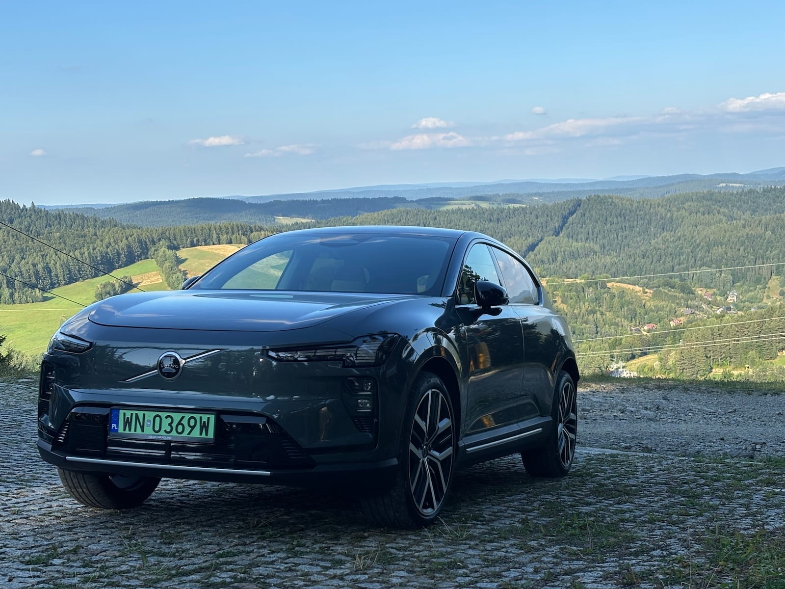 Volvo EX60 w górach, samochód stoi na bruku