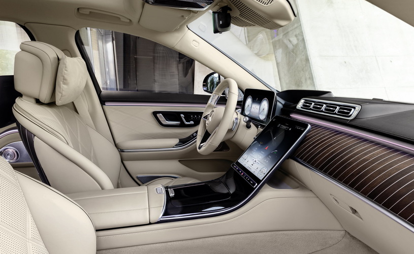Wnętrze Mercedes-Maybach: beżowe skórzane fotele, cyfrowa deska rozdzielcza, duży ekran, drewniane akcenty.