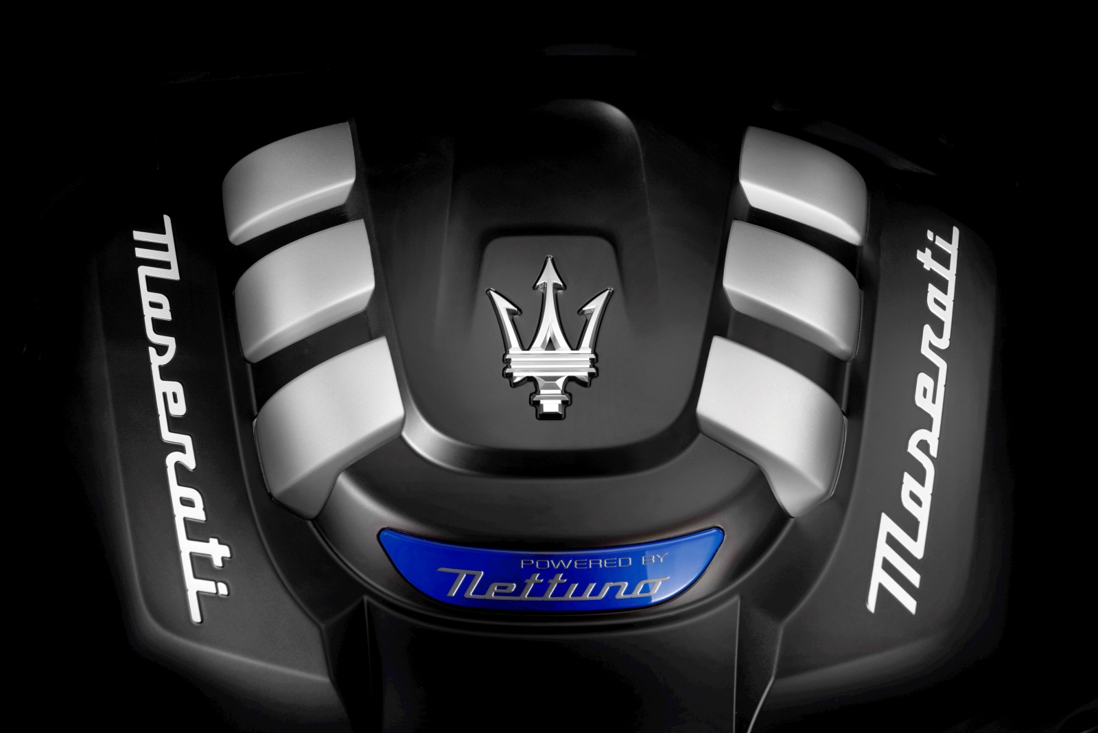 Pokrywa silnika Maserati Nettuno z logo trójzębu i napisem „Maserati” po bokach.