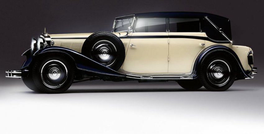 Mercedes-Maybach w stylu retro, kremowe nadwozie, czarne błotniki i dach, koła zapasowe po bokach.