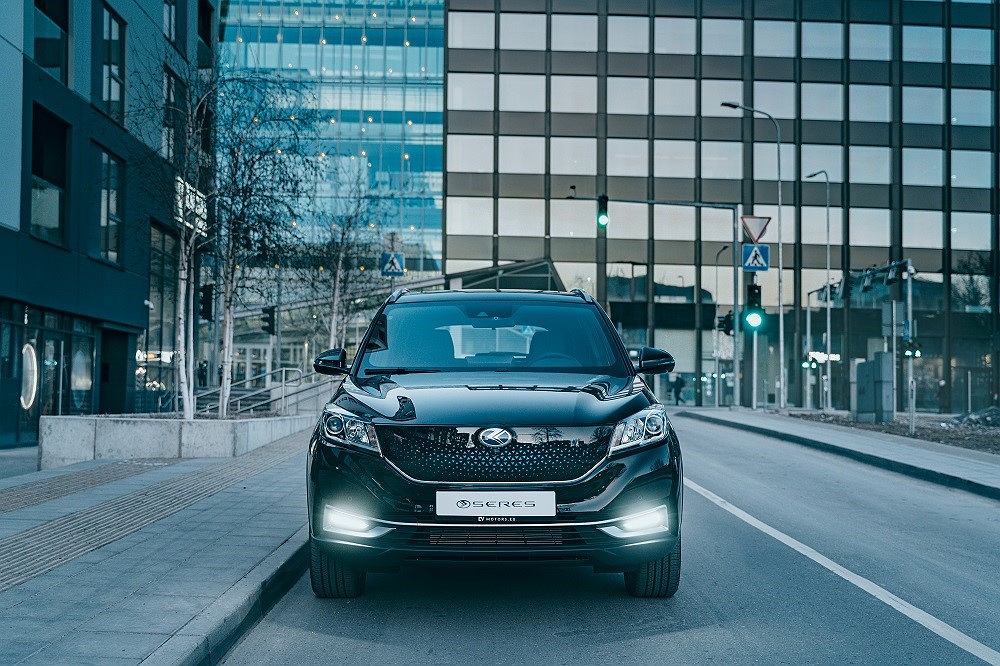 Czarny Seres 3 SUV zaparkowany przy miejskiej ulicy przed nowoczesnymi budynkami ze szkła.