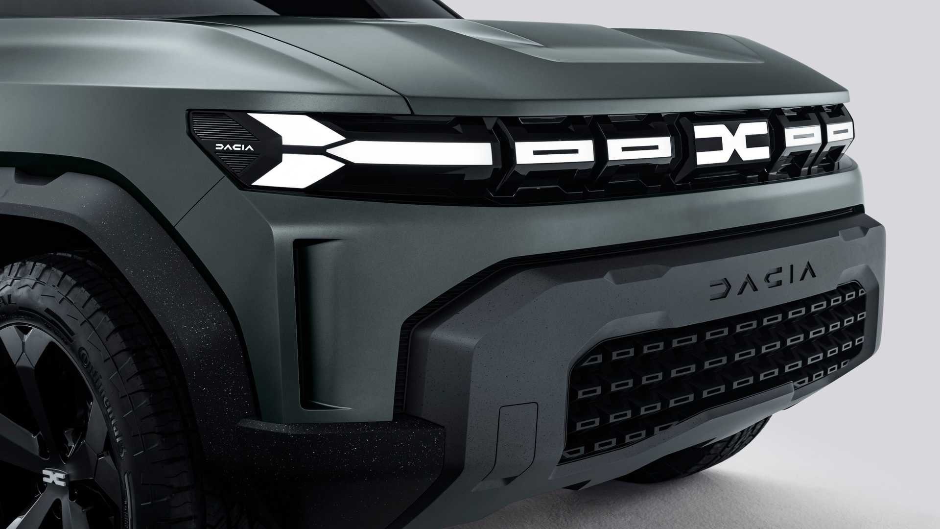 Przód ciemnozielonego Dacii Bigster z podświetlanym grillem, logo i masywnym zderzakiem.