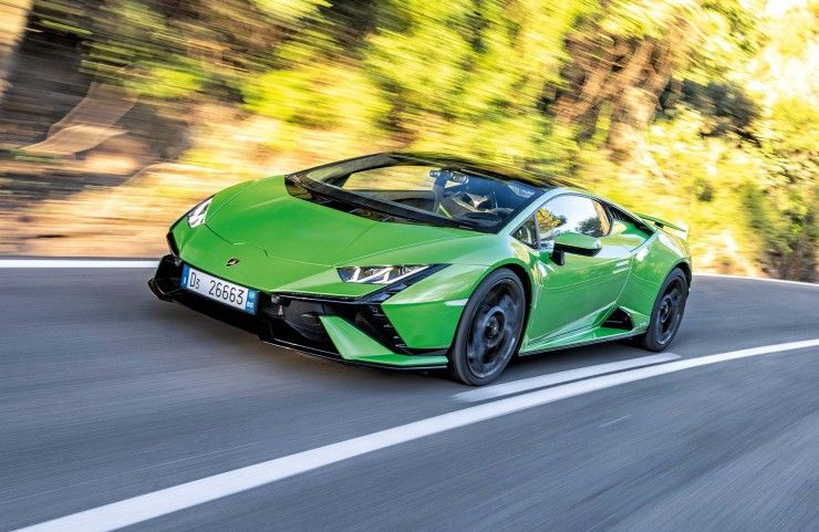 Zielony Lamborghini Huracan Tecnica pędzi po krętej drodze wśród drzew.