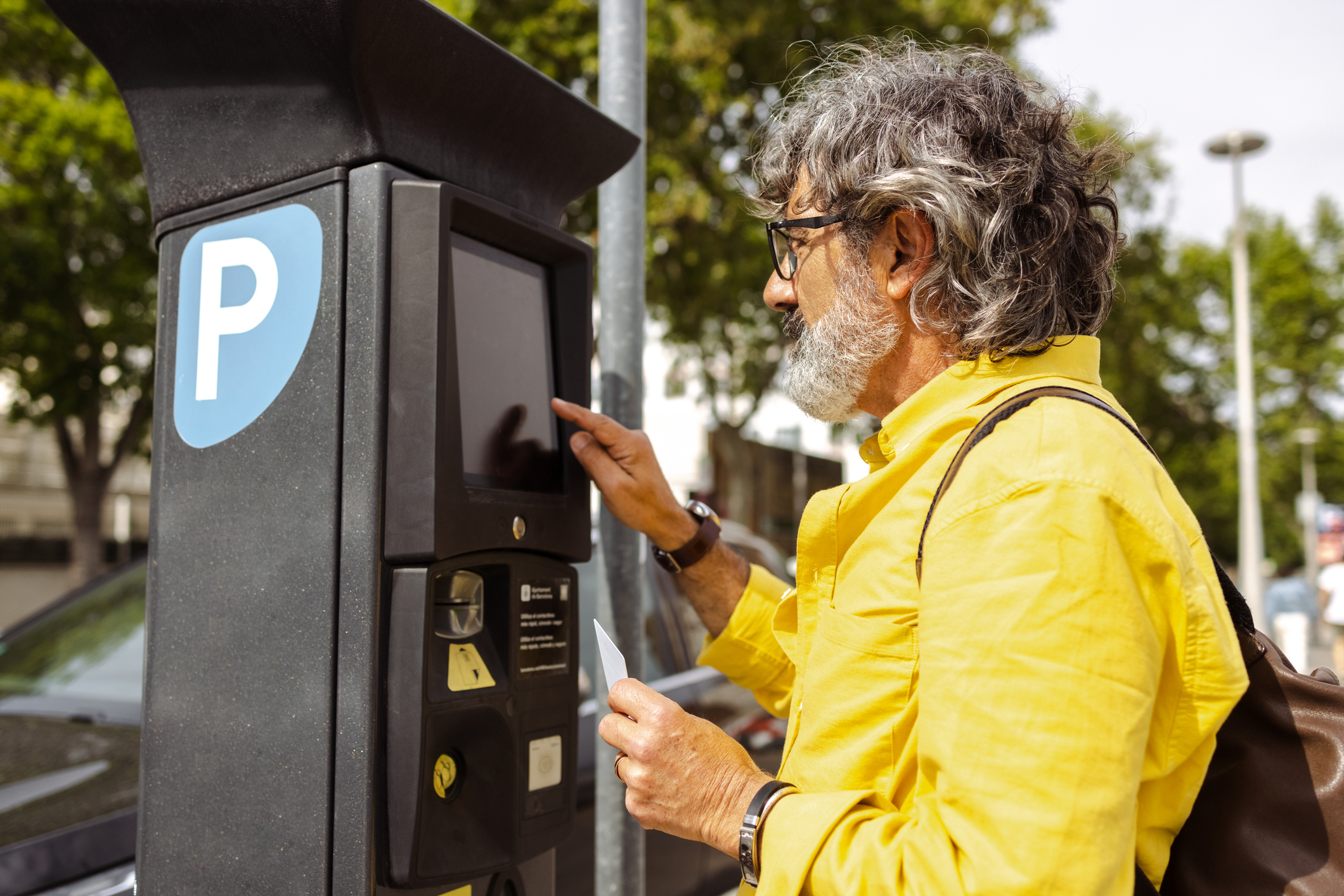 parkometr starszy mężczyzna płaci za postój