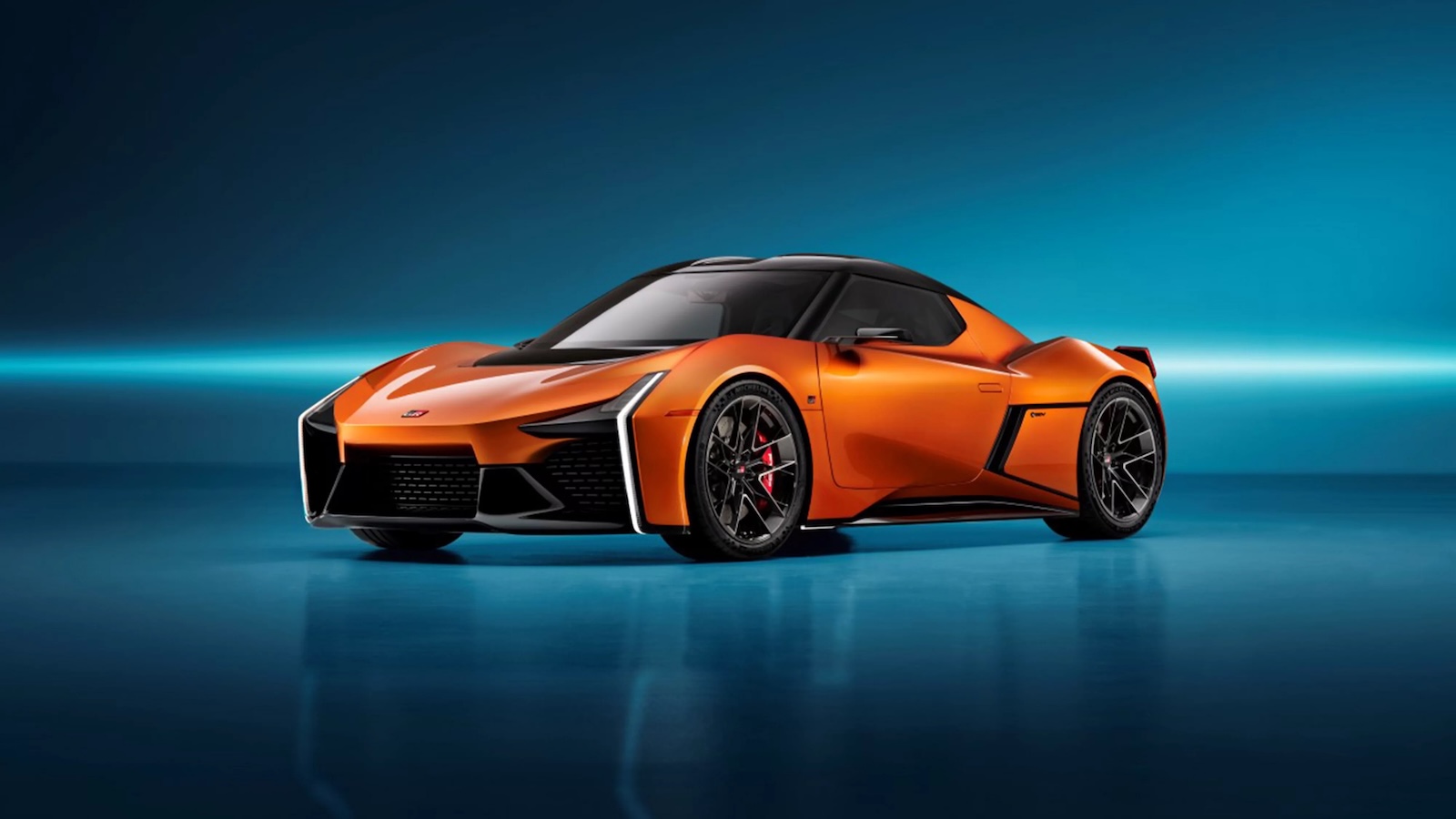Pomarańczowa sportowa Toyota z czarnymi akcentami stoi na błyszczącej niebieskiej powierzchni.