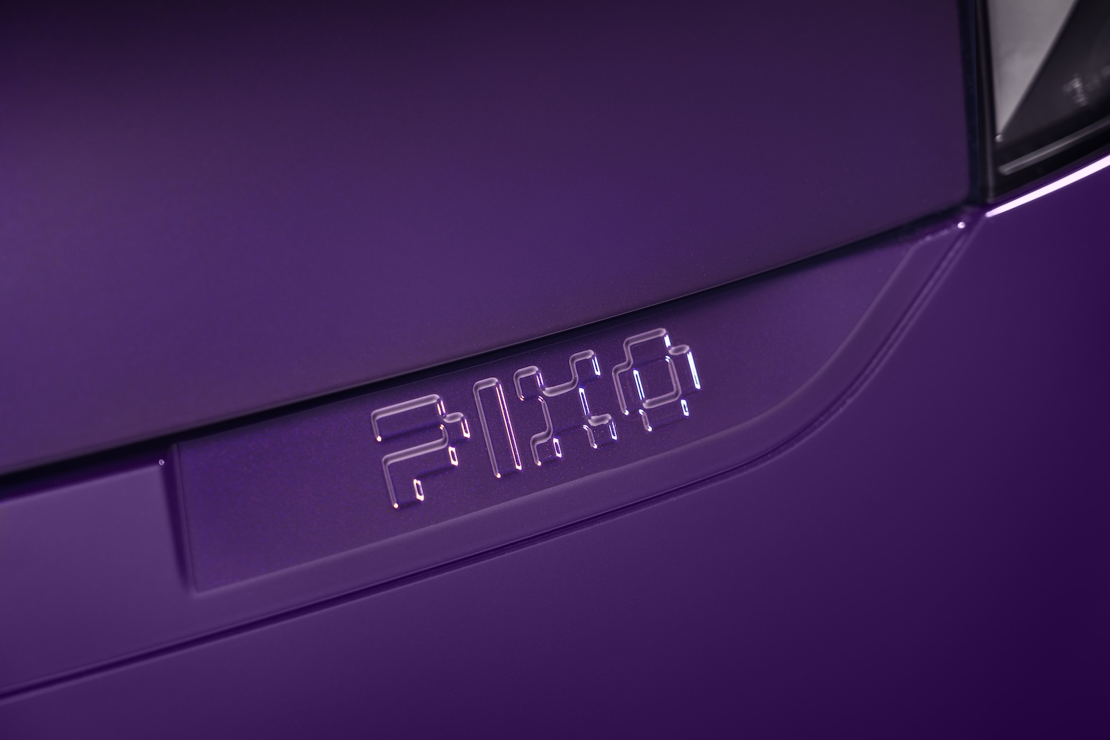 Close-up on "PIXO" 3D lettering below the hood