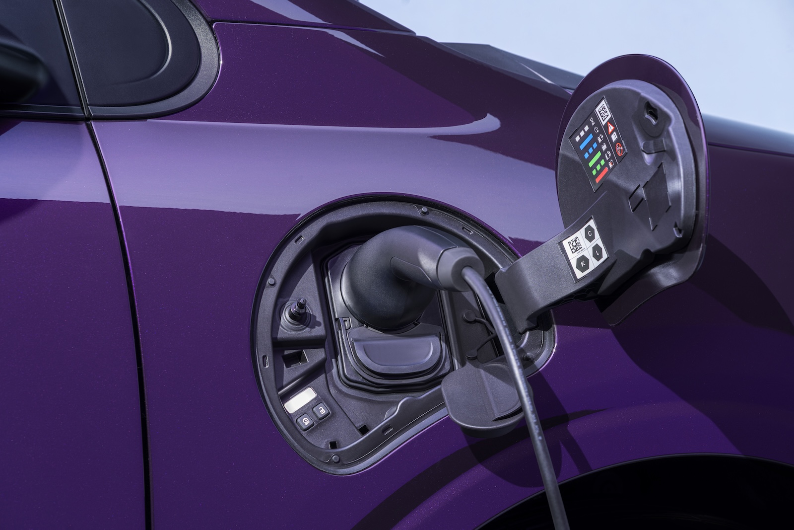 Photograph shows open Nissan PIXO fuel-filler compartment on a glossy purple car, highlighting vehicle refueling components.