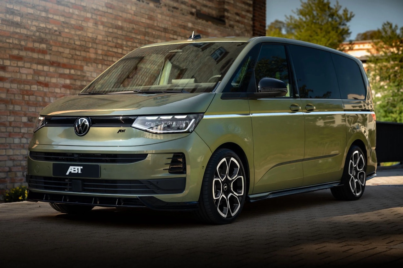Zielony Volkswagen z pakietem ABT stoi na podjeździe przed ceglanym murem i drzewami.
