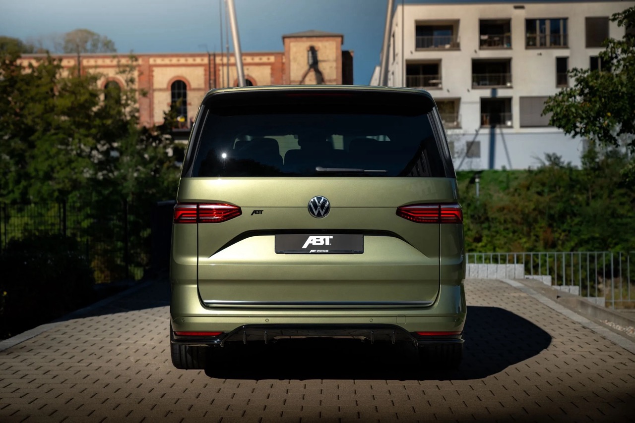 Zielony Volkswagen ABT stoi tyłem na parkingu, a w tle widać budynki i drzewa.