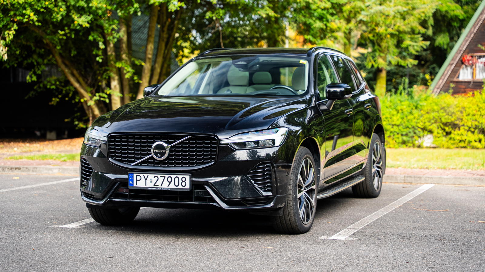 Czarne Volvo XC60 II zaparkowane na miejscu parkingowym.