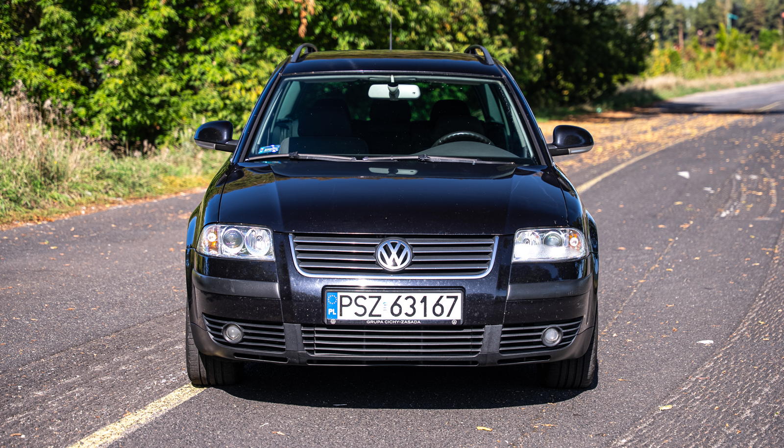 Czarny, używany VW Passat B5 kombi zaparkowany na asfaltowej drodze, widok z przodu.