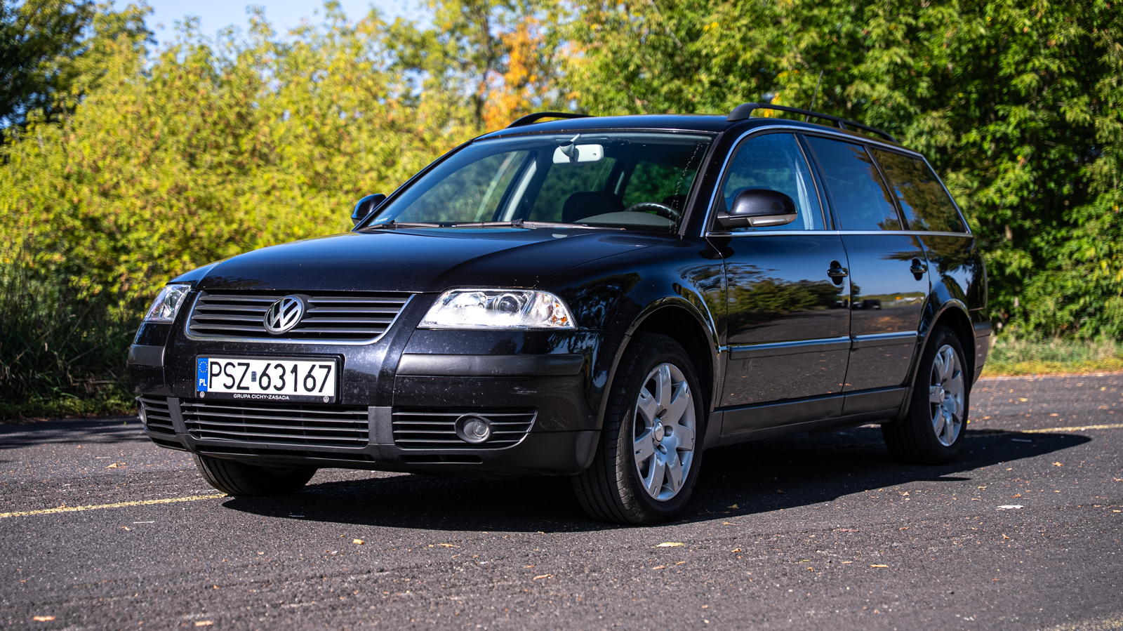 Czarny, używany VW Passat B5 kombi zaparkowany na asfalcie.