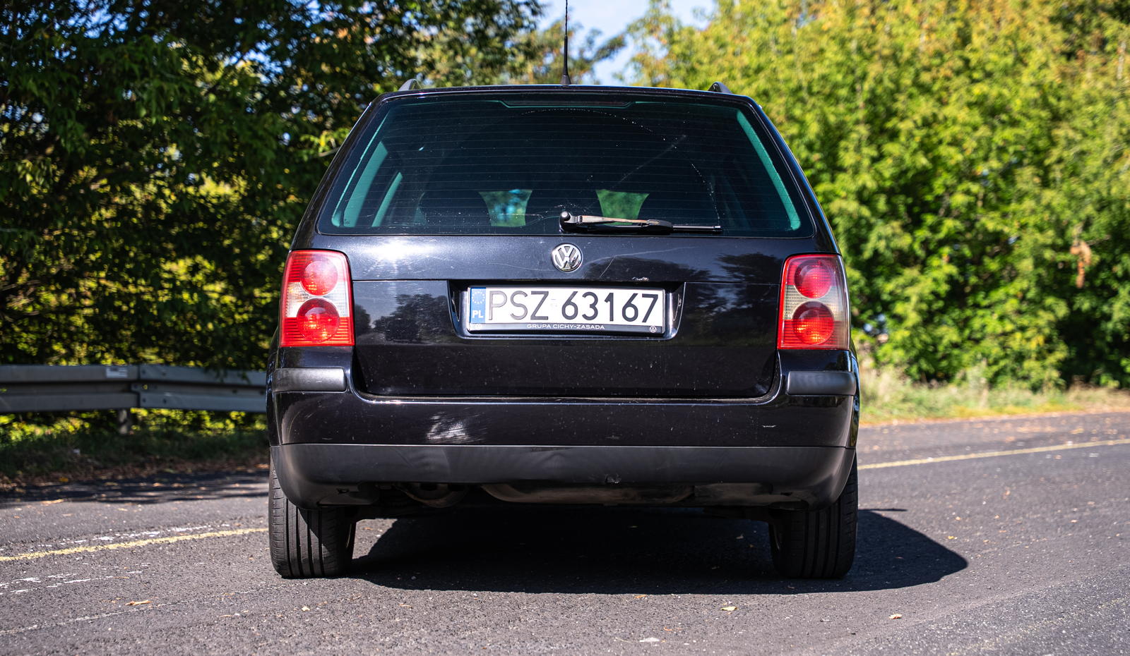 Czarny Volkswagen Golf kombi widziany od tyłu na asfalcie, w stylu VW Passat B5.