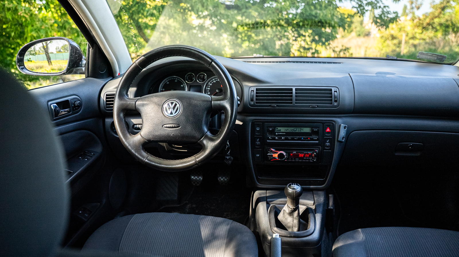 Wnętrze używanego VW Passata B5 z kierownicą, zestawem wskaźników i manualną skrzynią biegów.