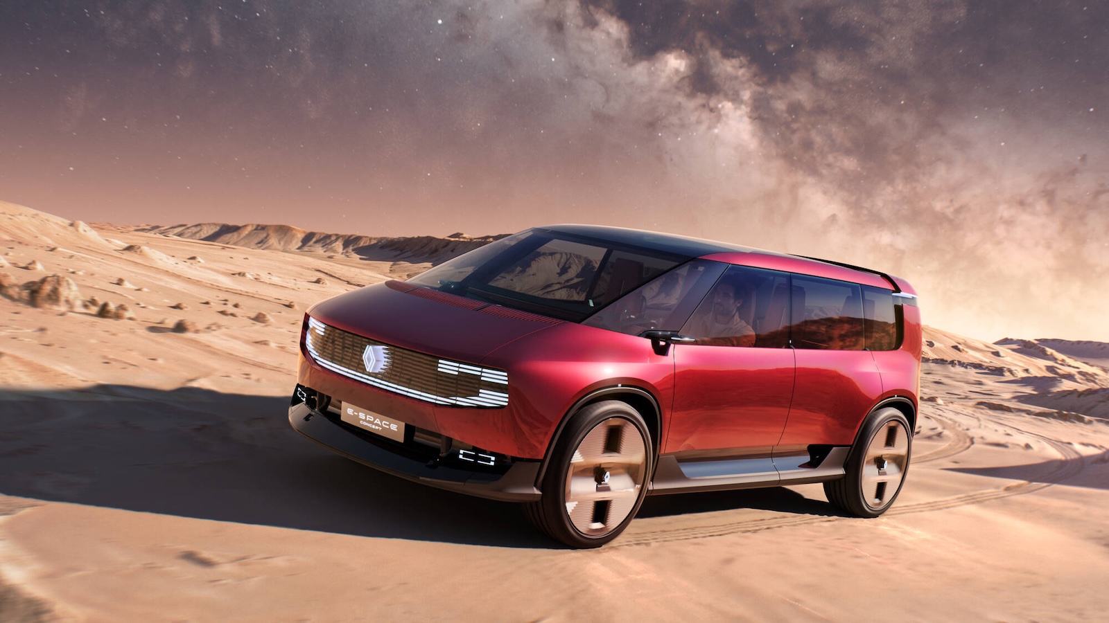 Czerwony samochód koncepcyjny Renault E-Space jadący przez pustynię pod rozgwieżdżonym niebem.