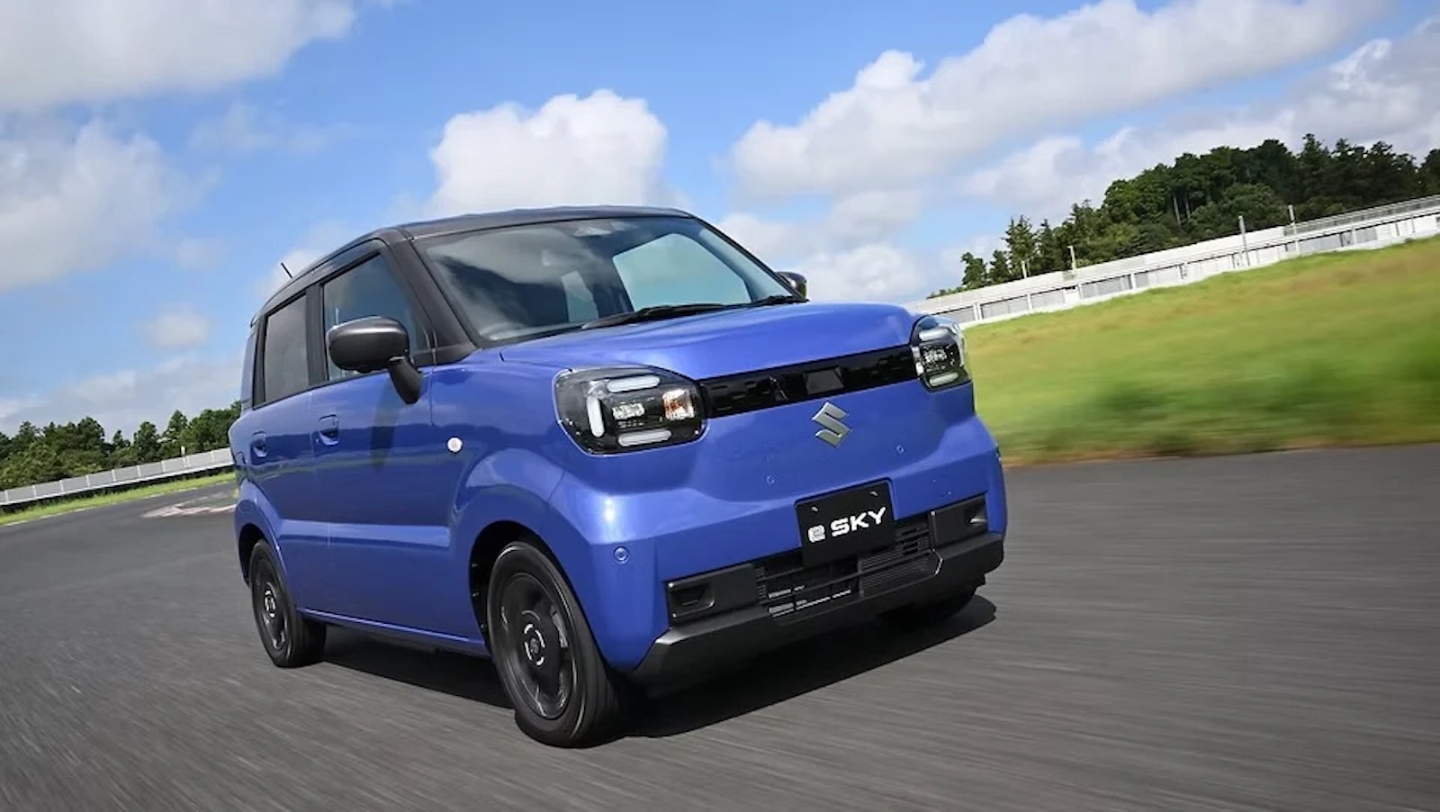 Niebieski Suzuki E-Sky jadący po torze wyścigowym.