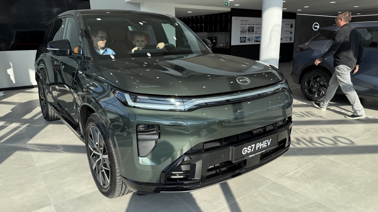 Zielony hybrydowy GAC GS7 PHEV zaparkowany w salonie sprzedaży.