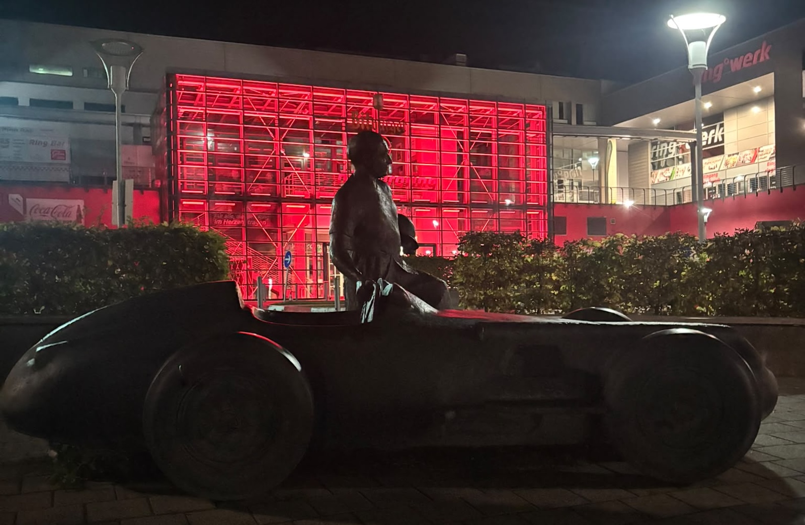 Nocna rzeźba przedstawiająca kierowcę w zabytkowym samochodzie wyścigowym z toru Nürburgring.