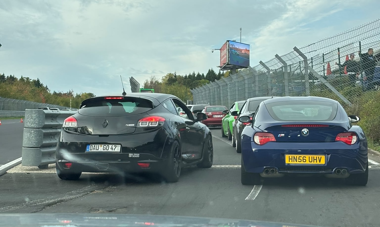 Czarny Renault Megane i niebieskie BMW Z4 w kolejce na torze Nürburgring.